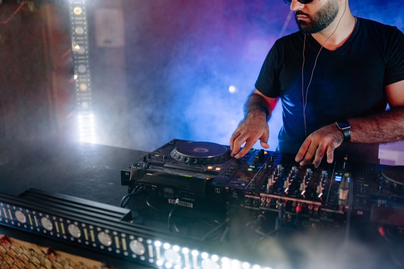 DJ performing under colourful party lights