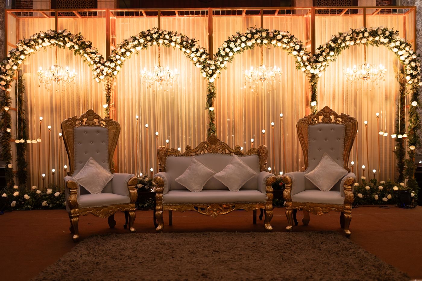 Wedding stage with ornate chairs and flowers